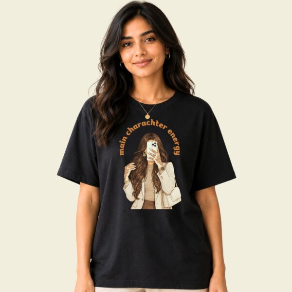 Desi girl graphic tee front view showing 'main character energy' lettering and retro illustration